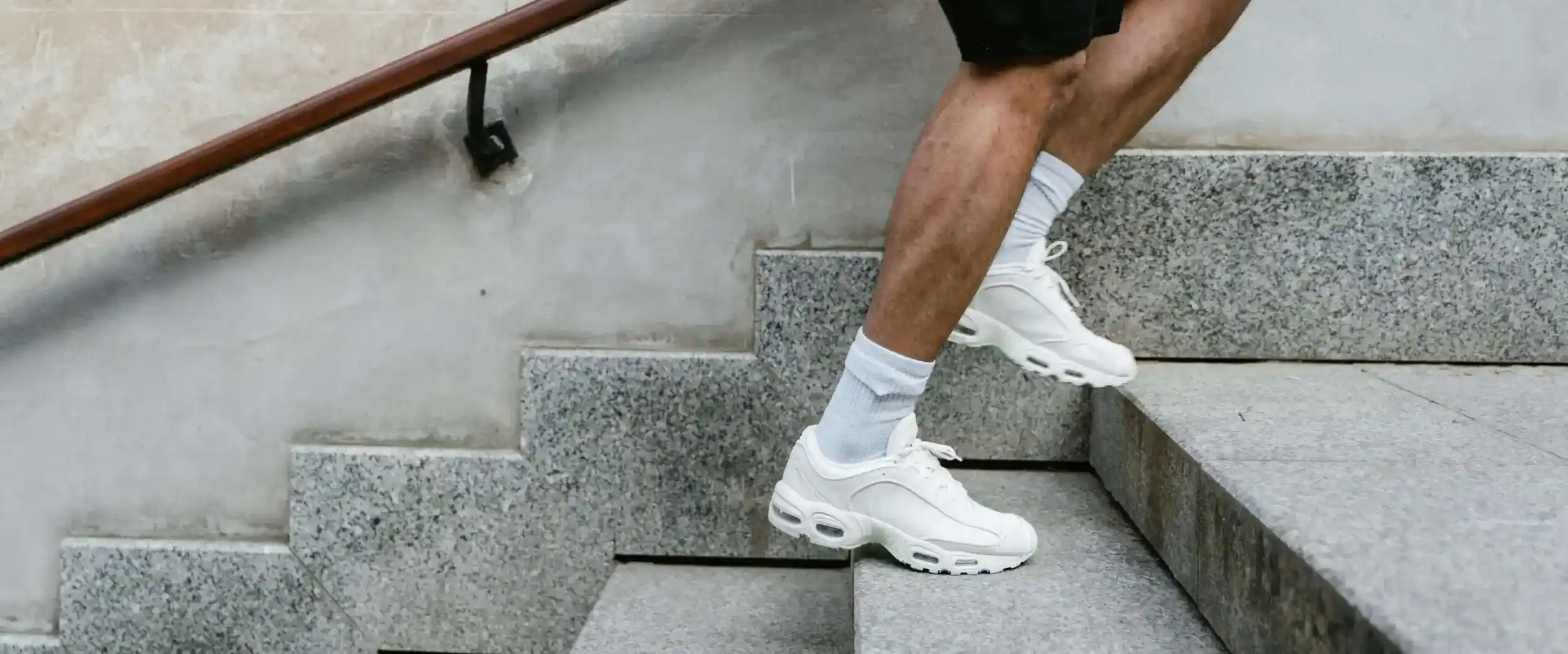 Closeup of white shoes of running up concrete stairs